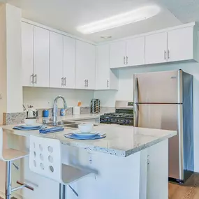 a kitchen with an island and stainless steel refrigerator