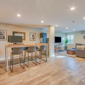 a living room with a bar with three stools