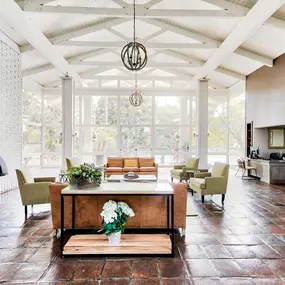 a large living room with a fireplace and a table and chairs