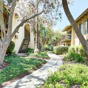 a sidewalk in front of a building with trees