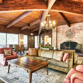 a living room with furniture and a brick fireplace