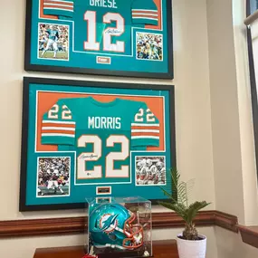 Welcome to the Hall of Fame corner at our office!

As a lifelong Dolphins fan, I’m proud to showcase legends Bob Griese and Mercury Morris—key players from the 1972 Perfect Season team. That kind of excellence, teamwork, and preparation is exactly what we strive for every day here at the Perry Unwalla State Farm office.