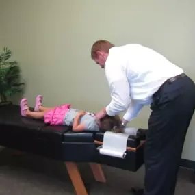 Dr Jay Harrison adjusting a child at Lifetime Family Health Center in Grapevine Texas