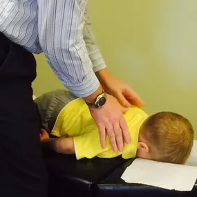 Dr Jay Harrison adjusting a child at Lifetime Family Health Center in Grapevine Texas