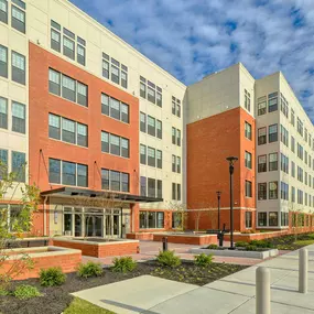 an exterior view of an apartment building with a sidewalk and courtyard