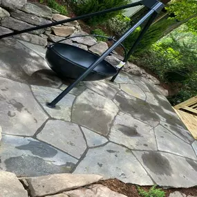 Stone patio with retaining wall and fire pit