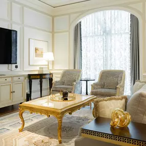 Caesars Palace Chateau Villa living room with sofa, coffee table, sitting chairs, TV, dresser and large window