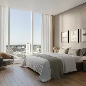 a bedroom with a bed and a window with a city view