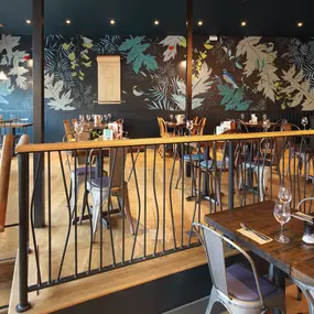 Contemporary Italian dining at Zizzi Bexleyheath with bright, welcoming interiors. Fairy lights light up the ceiling, whilst exotic art walls create a captivating backdrop, energising the dining experience.