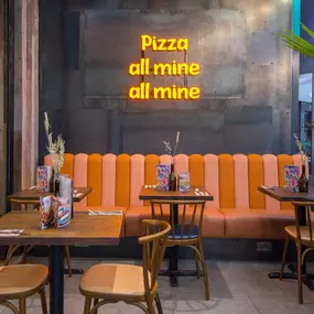 Zizzi Metro Centre, lively interior with vibrant foliage, neon lighting and bold seating.