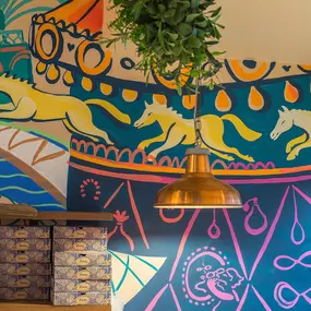 Zizzi Metro Centre, lively interior with vibrant foliage, neon lighting and bold seating.