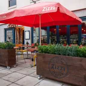 Zizzi Leamington Spa, inviting outdoor seating with greenery and shaded umbrella.