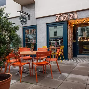 Zizzi Leamington Spa, inviting outdoor seating with greenery and shaded umbrella.