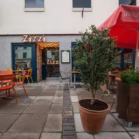 Zizzi Leamington Spa, inviting outdoor seating with greenery and shaded umbrella.