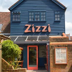 Zizzi Farnham, tucked-away courtyard with covered outdoor terrace and glowing sign.