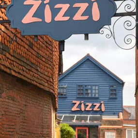 Zizzi Farnham, tucked-away courtyard with covered outdoor terrace and glowing sign.