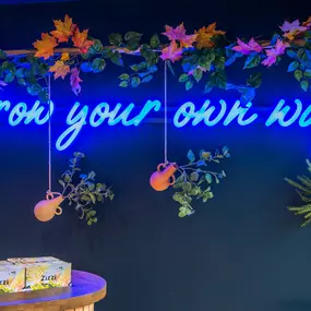 Zizzi Farnham interior view of neon of sign saying 'Grow your own way'.