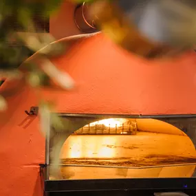Zizzi Farnham, cozy interior with vibrant murals and hanging orange foliage.