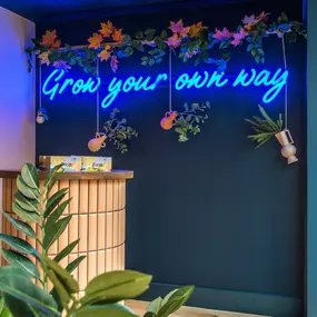 Zizzi Farnham, cozy interior with vibrant murals and hanging orange foliage.