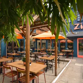 Zizzi Farnham, tucked-away courtyard with covered outdoor terrace and glowing sign.
