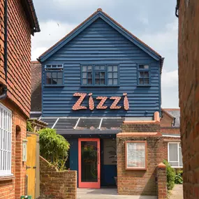 Zizzi Farnham, tucked-away courtyard with covered outdoor terrace and glowing sign.