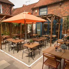 Zizzi Farnham, tucked-away courtyard with covered outdoor terrace and glowing sign.