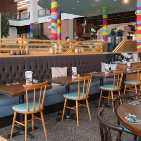 Interior view of Zizzi Leith, bright, open dining with colourful seating and large windows.