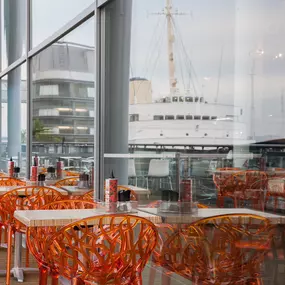 Exterior view of Zizzi Leith, showing vibrant outdoor seating area overlookingThe Royal Yacht Britannia.