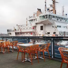 Exterior view of Zizzi Leith, showing vibrant outdoor seating area overlooking The Royal Yacht Britannia.