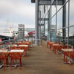Exterior view of Zizzi Leith, showing vibrant outdoor seating area overlooking The Royal Yacht Britannia.