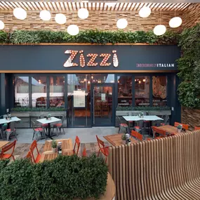 Exterior entrance of Zizzi Hull with greenery wall and outdoor seating.