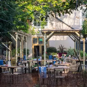 Zizzi Canterbury garden area with tables and chairs to enjoy the summers day surrounded by vibrant foliage.