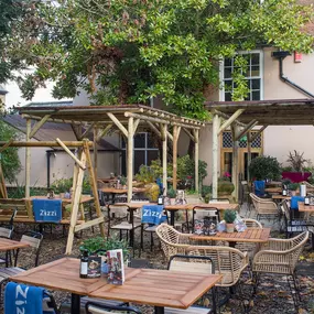 Zizzi Canterbury garden area with tables and chairs to enjoy the summers day surrounded by vibrant foliage.