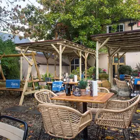Zizzi Canterbury garden area with tables and chairs to enjoy the summers day surrounded by vibrant foliage.
