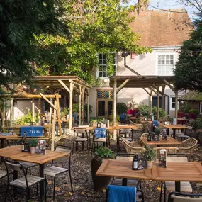 Zizzi Canterbury garden area with tables and chairs to enjoy the summers day surrounded by vibrant foliage.