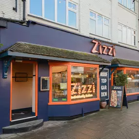 Exterior view of Zizzi Stratford-upon-Avon, classic dark blue frontage mixed with vibrant orange and the iconic Zizzi signage.