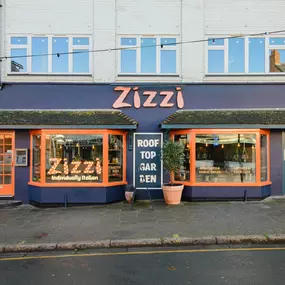 Exterior view of Zizzi Stratford-upon-Avon, classic dark blue frontage mixed with vibrant orange and the iconic Zizzi signage.