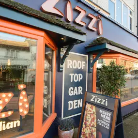 Exterior view of Zizzi Stratford-upon-Avon, classic dark blue frontage mixed with vibrant orange and the iconic Zizzi signage.