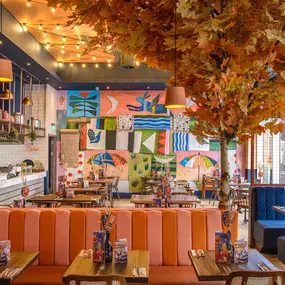 Zizzi Gloucester Quays, colourful mural wall and signature indoor tree feature.
