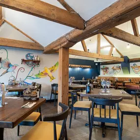 Zizzi Norwich, colourful mural wall and mixed seating styles.
