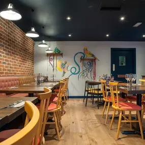 Zizzi Norwich, colourful mural wall and mixed seating styles.
