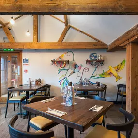 Zizzi Norwich, colourful mural wall and mixed seating styles.