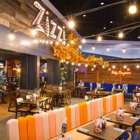 Interior view of Zizzi Sheffield Meadowhall's vibrant modern dining area at with rustic decor and natural accents.