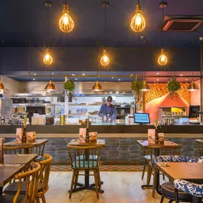 Interior view of Zizzi Sheffield Meadowhall's vibrant modern dining area at with rustic decor and natural accents.