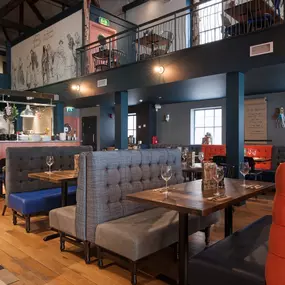 Zizzi Chichester, interior with green feature wall and wooden seating