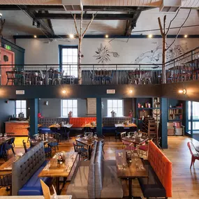 Zizzi Chichester, interior with green feature wall and wooden seating