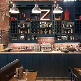 Zizzi Chichester, interior with green feature wall and wooden seating