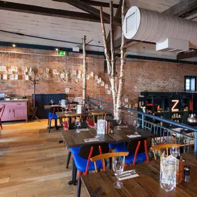 Zizzi Chichester, bright interior with brick walls create a classic design and wooden seating.