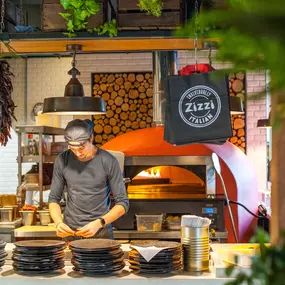 Zizzi Hereford, vibrant dining with hanging ceiling foliage and warm lighting.