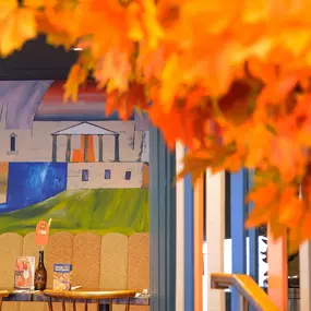 Zizzi Chiswick, showcases wooden tables and chairs beneath decorative copper foliage suspended from the ceiling.